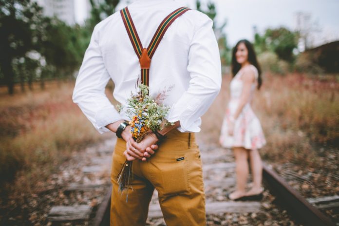 man giving flowers to woman