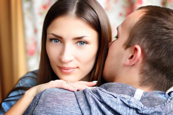 man kissing woman